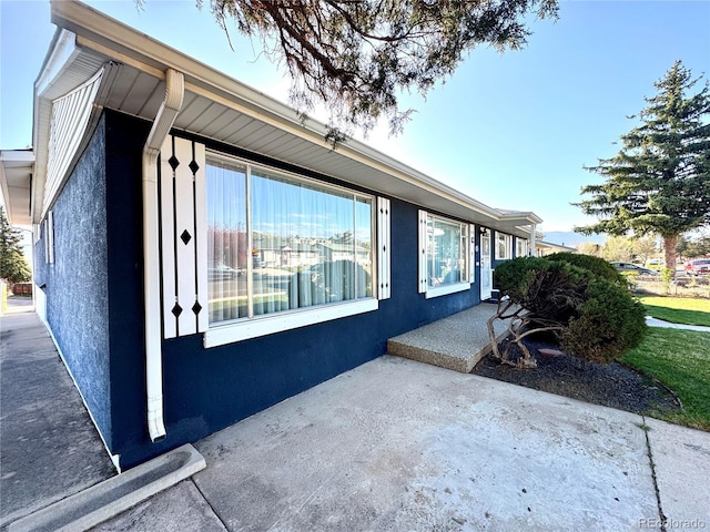 view of side of property with a patio and stucco siding
