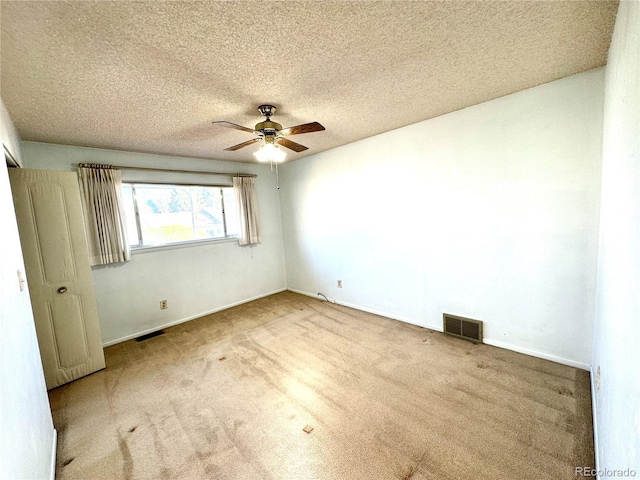 unfurnished bedroom with ceiling fan, carpet floors, a textured ceiling, and visible vents