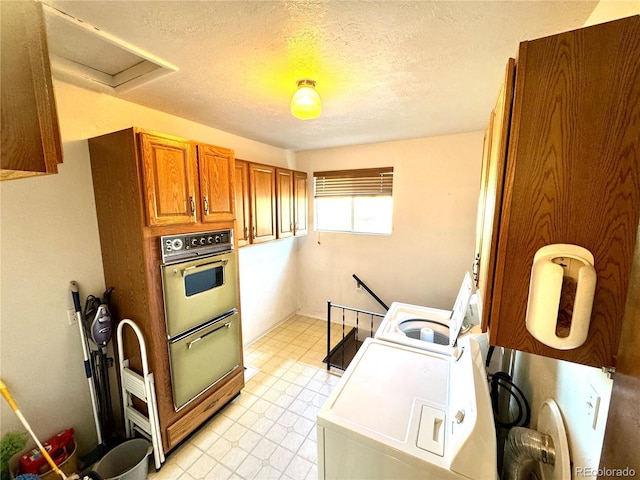 laundry area with a textured ceiling, attic access, light floors, washer / clothes dryer, and laundry area