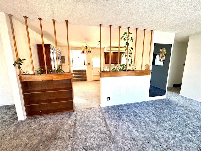 interior space with a chandelier, carpet floors, and a textured ceiling