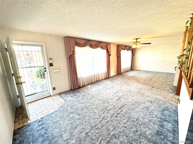 interior space featuring carpet floors, a textured ceiling, ceiling fan, and plenty of natural light