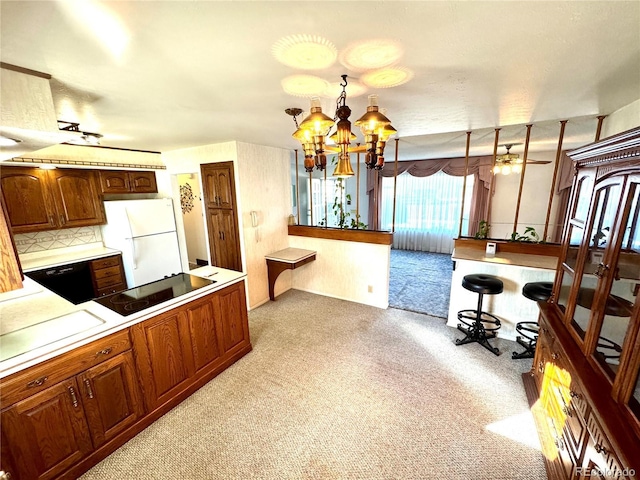 3498 Corbett Ln, Colorado Springs, CO 80907 - kitchen featuring freestanding refrigerator, black electric cooktop, light colored carpet, light countertops, and a chandelier