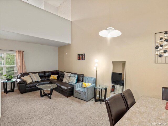 living room featuring a towering ceiling and carpet flooring