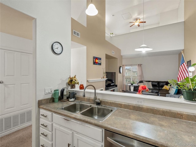kitchen with a sink, white cabinetry, decorative light fixtures, open floor plan, and ceiling fan