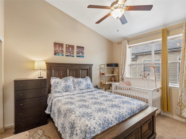 bedroom with vaulted ceiling, light colored carpet, baseboards, and a ceiling fan