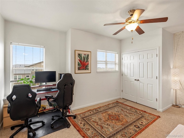 carpeted office featuring healthy amount of natural light, ceiling fan, and baseboards