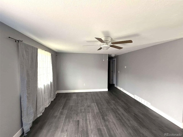 spare room featuring ceiling fan, dark hardwood / wood-style flooring, and a textured ceiling