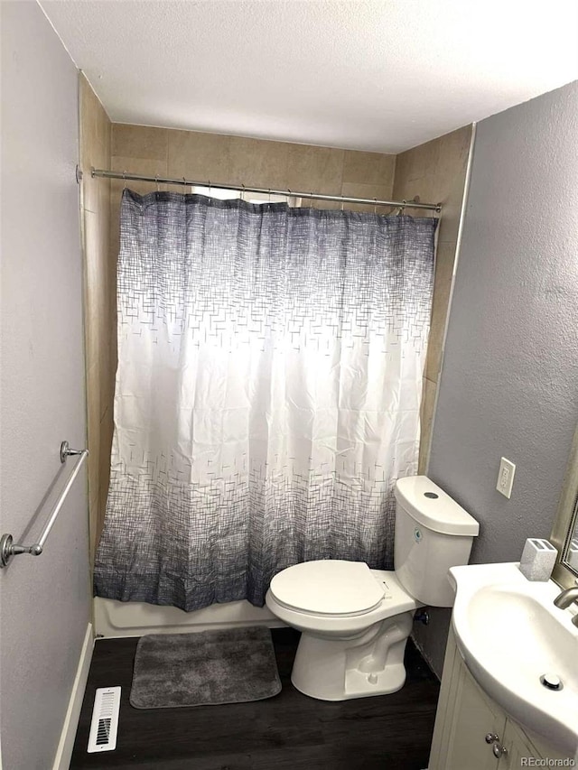 full bathroom featuring shower / bath combo, wood-type flooring, a textured ceiling, toilet, and vanity