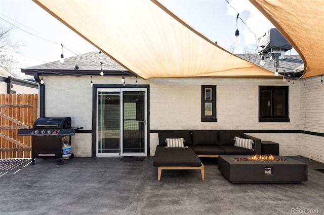 view of patio with fence, an outdoor living space with a fire pit, and a grill