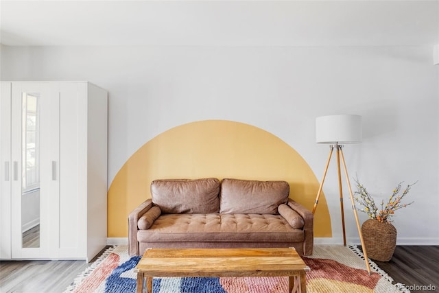living area with baseboards and wood finished floors