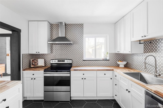 kitchen featuring a sink, wood counters, wall chimney exhaust hood, and appliances with stainless steel finishes