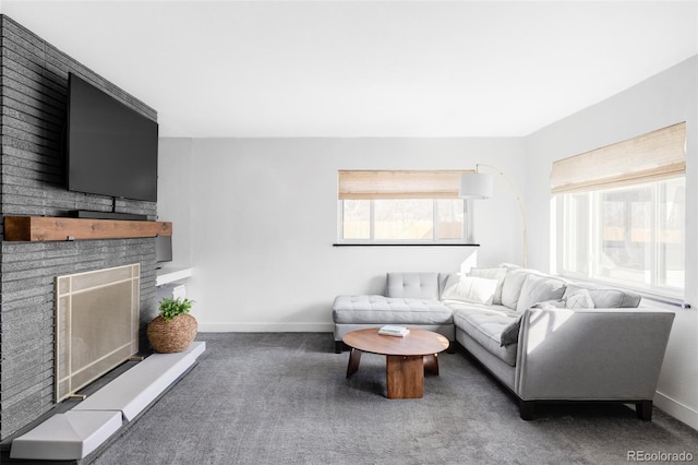 living room featuring a healthy amount of sunlight, baseboards, a fireplace, and carpet