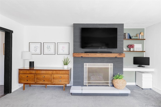 carpeted living room featuring baseboards and a fireplace