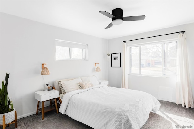 carpeted bedroom featuring baseboards, a ceiling fan, and multiple windows