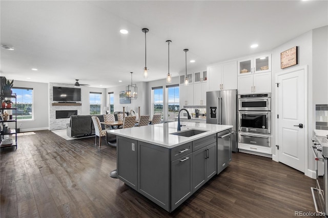 kitchen featuring a sink, a warming drawer, gray cabinetry, white cabinets, and stainless steel appliances