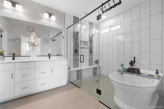 bathroom with a stall shower, double vanity, a soaking tub, and tile patterned floors