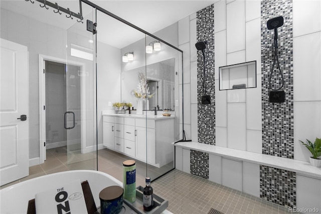full bath featuring a shower stall, a freestanding tub, vanity, and tile patterned floors