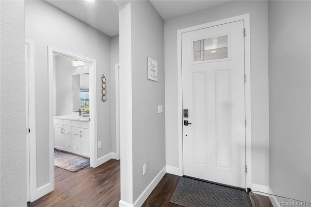 entrance foyer with dark wood-type flooring and baseboards