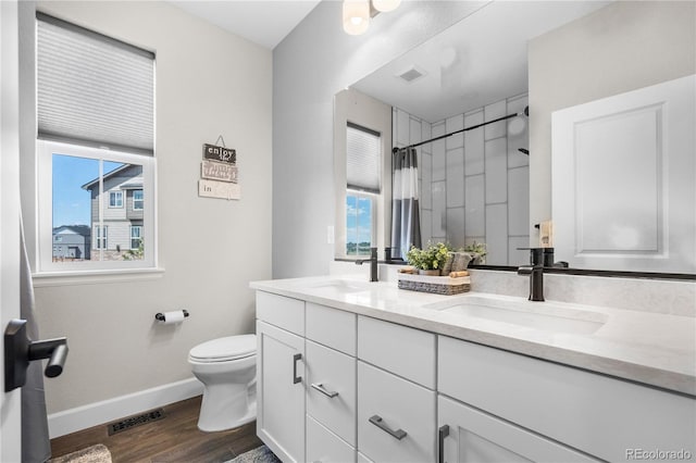 full bathroom with plenty of natural light, baseboards, wood finished floors, and toilet