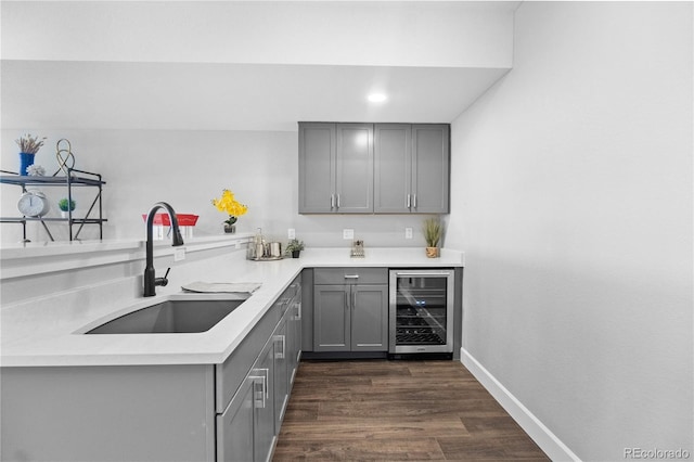 indoor bar featuring beverage cooler, dark wood finished floors, baseboards, and recessed lighting