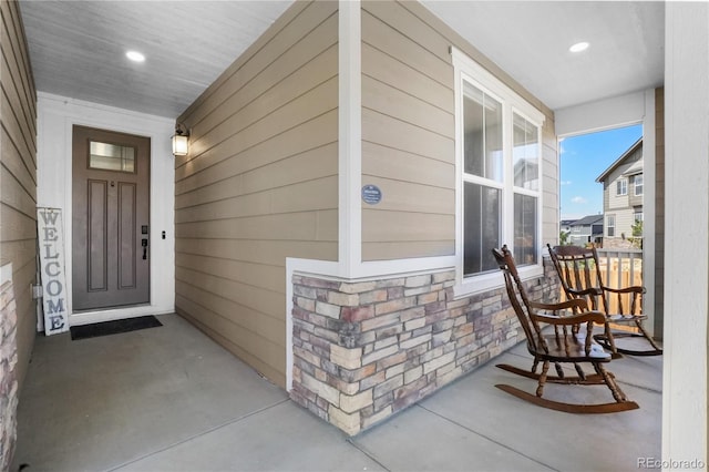 entrance to property with covered porch and stone siding