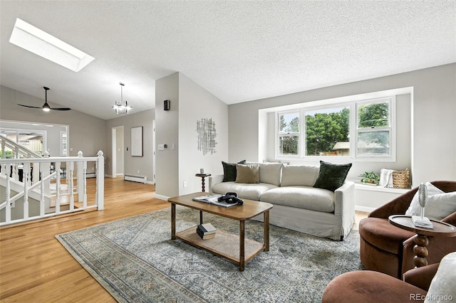 1092 E 16th Ave, Broomfield, CO 80020 - living area with a baseboard radiator, a skylight, lofted ceiling, wood finished floors, and a ceiling fan