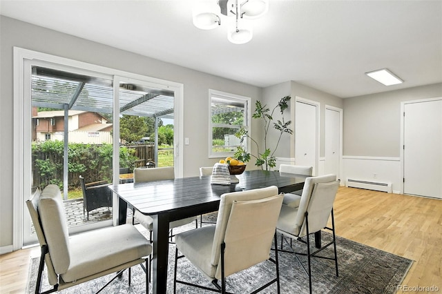 1092 E 16th Ave, Broomfield, CO 80020 - dining area featuring a baseboard heating unit, light wood-type flooring, and a chandelier