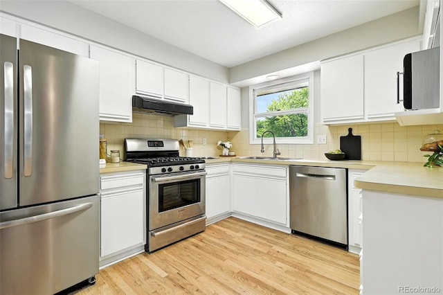 1092 E 16th Ave, Broomfield, CO 80020 - kitchen featuring stainless steel appliances, under cabinet range hood, light countertops, light wood-style flooring, and backsplash