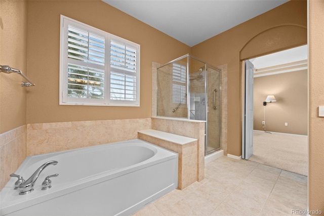 bathroom with tile patterned flooring, a bath, and a shower stall