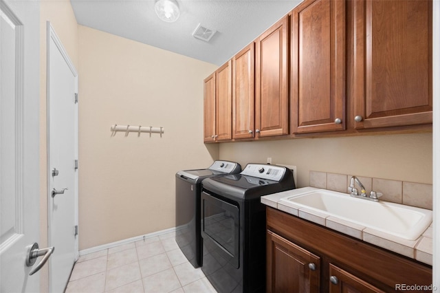 laundry room featuring cabinet space, a sink, baseboards, visible vents, and washing machine and dryer