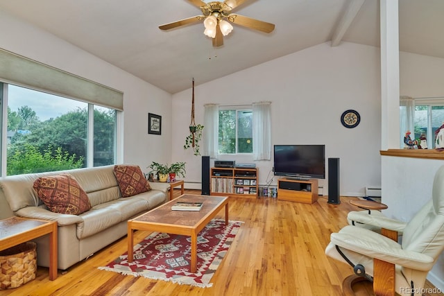 living room with plenty of natural light, lofted ceiling with beams, and light wood-type flooring