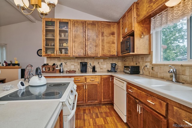 kitchen with lofted ceiling, sink, pendant lighting, white appliances, and decorative backsplash