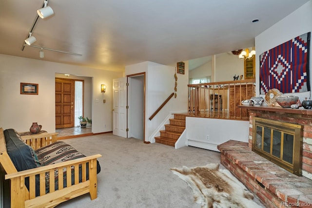 living room with a brick fireplace, baseboard heating, track lighting, carpet floors, and a notable chandelier