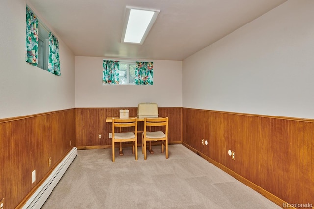 dining area featuring wooden walls, light carpet, and baseboard heating