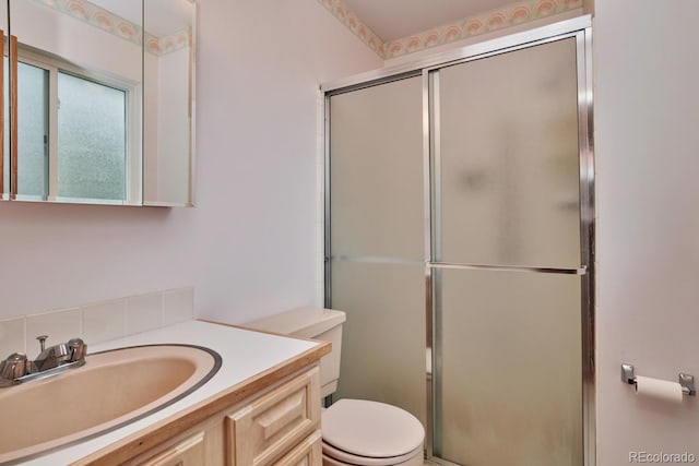 bathroom featuring vanity, toilet, and walk in shower