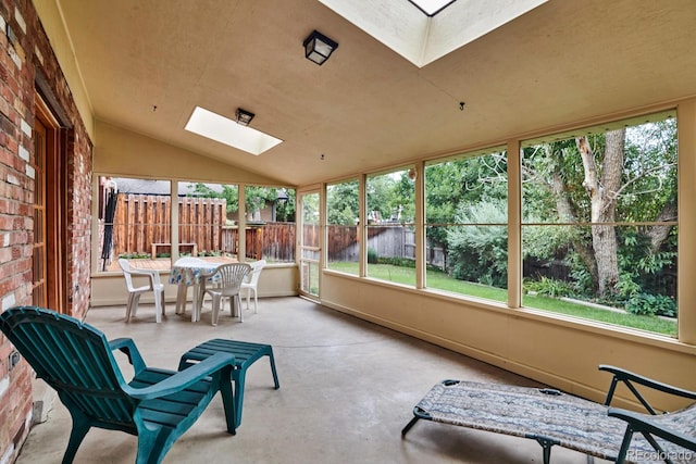 sunroom featuring vaulted ceiling with skylight