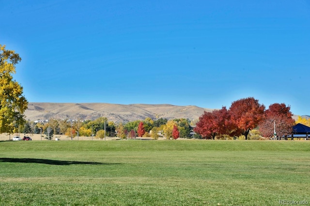 surrounding community featuring a mountain view, a lawn, and a rural view