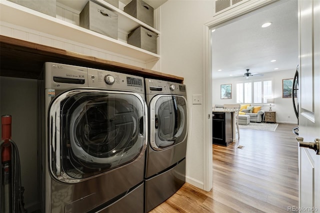 washroom featuring light wood finished floors, visible vents, ceiling fan, laundry area, and independent washer and dryer