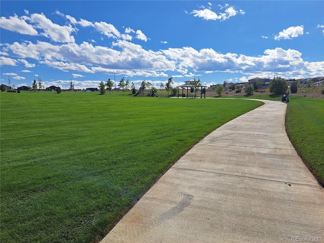 view of community featuring playground community and a lawn