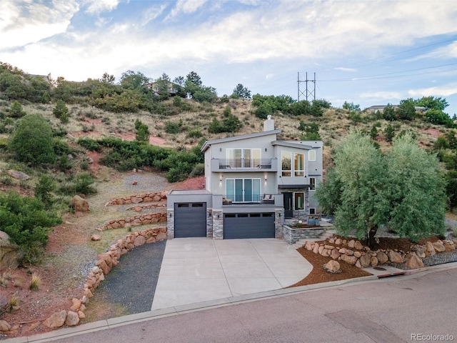 view of front of property featuring a balcony and a garage