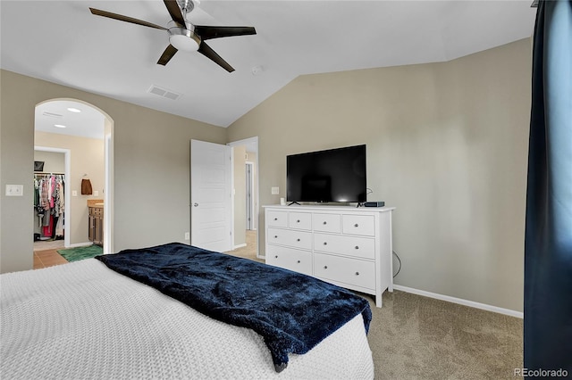 25486 E 4th Pl, Aurora, CO 80018 - bedroom featuring arched walkways, lofted ceiling, light carpet, ceiling fan, and a walk in closet