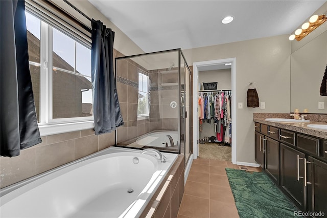 25486 E 4th Pl, Aurora, CO 80018 - bathroom featuring a garden tub, a stall shower, a spacious closet, double vanity, and tile patterned floors