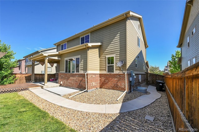 25486 E 4th Pl, Aurora, CO 80018 - rear view of house with brick siding, a fenced backyard, a wooden deck, and a patio