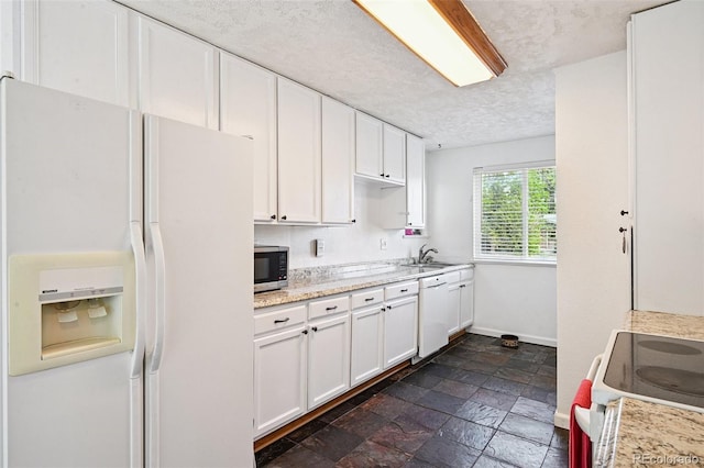 3350 W 94th Ave, Westminster, CO 80031 - kitchen featuring white appliances, white cabinetry, a textured ceiling, stone tile floors, and light stone counters