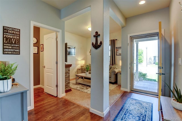 entryway with wood finished floors, baseboards, and recessed lighting