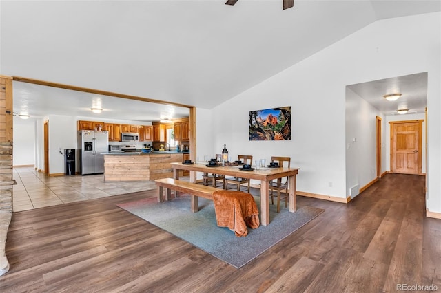 dining area with ceiling fan, high vaulted ceiling, and light hardwood / wood-style flooring