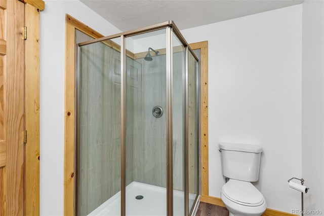 bathroom with toilet and a shower with shower door