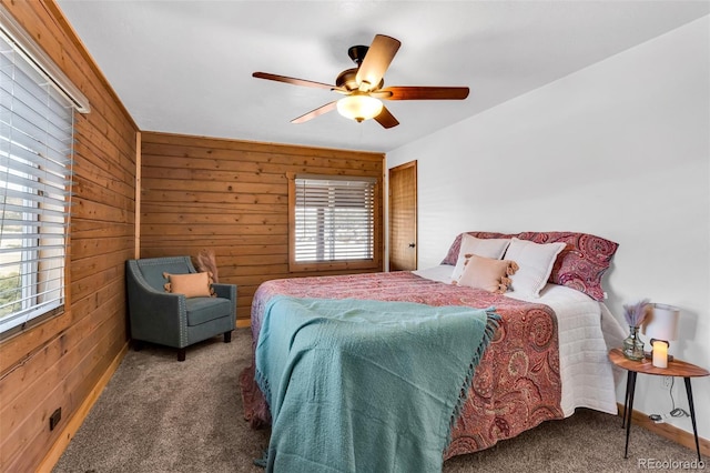 bedroom with dark colored carpet, ceiling fan, and wooden walls