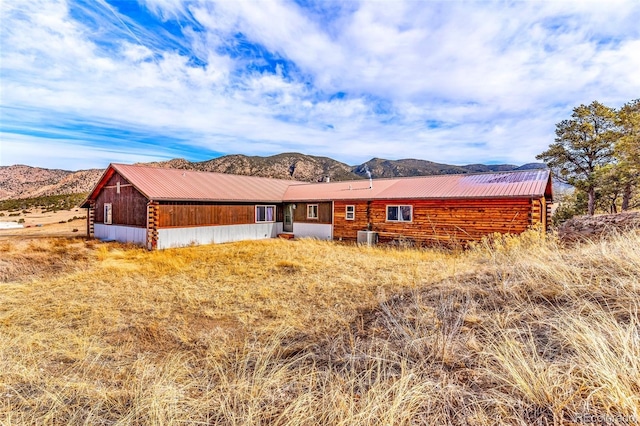 view of front of property featuring a mountain view and central AC unit