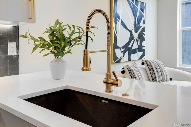 kitchen view of a sink and light countertops